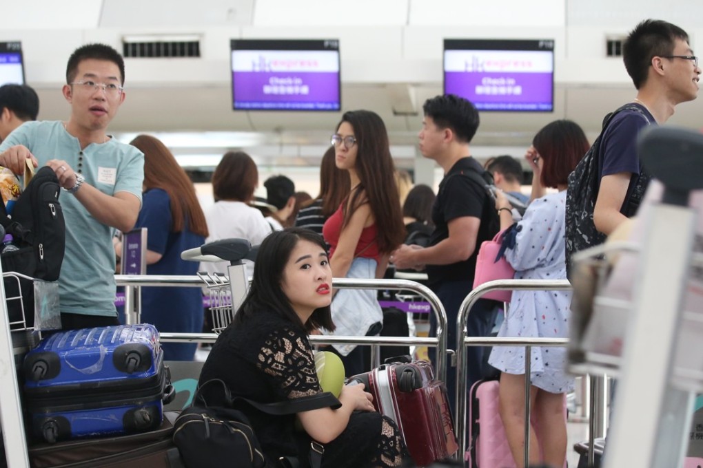 Hongkongers queue at the city’s airport to board a holiday flight. Many say they keep trips short so work doesn’t pile up while they are away. Photo: K.Y. Cheng