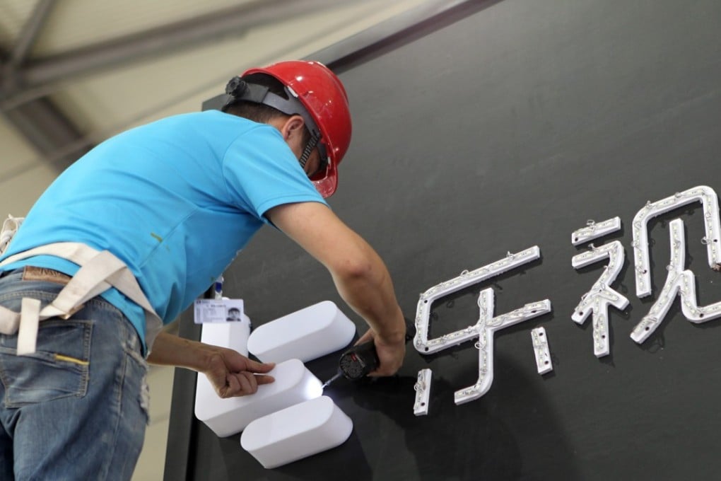 A worker installs the logo of LeEco, formerly known as Leshi or LeTV, in preparation for the 2016 International Consumer Electronics Show Asia (CES Asia 2016) in Shanghai on 10 May 2016. Photo: ImagineChina