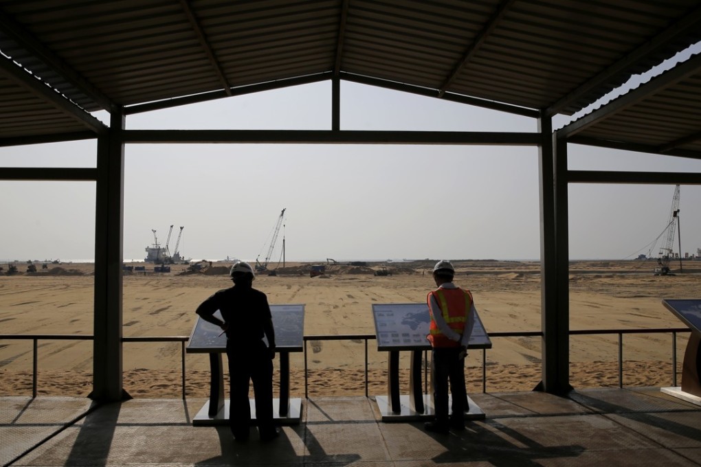 Visitors read information posted about land reclaimed for the Port City Colombo project in Colombo, Sri Lanka, on January 2. The project was initiated as part of China's “Belt and Road Initiative” and will include an international financial district, plus residential and entertainment zones. Photo: AP