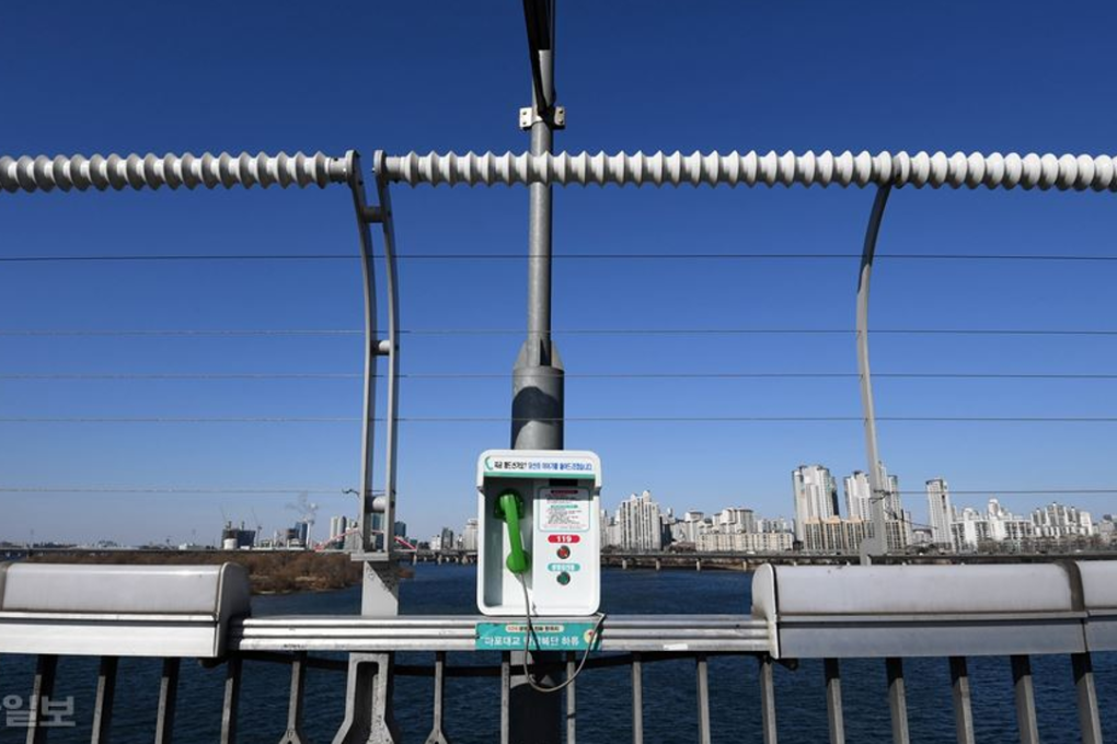 A phone and fence on the Mapo Bridge in Seoul aim to prevent suicide. The phone directly connects the caller to an expert in suicide prevention. Photo: Suh Jae-hoon/Korea Times