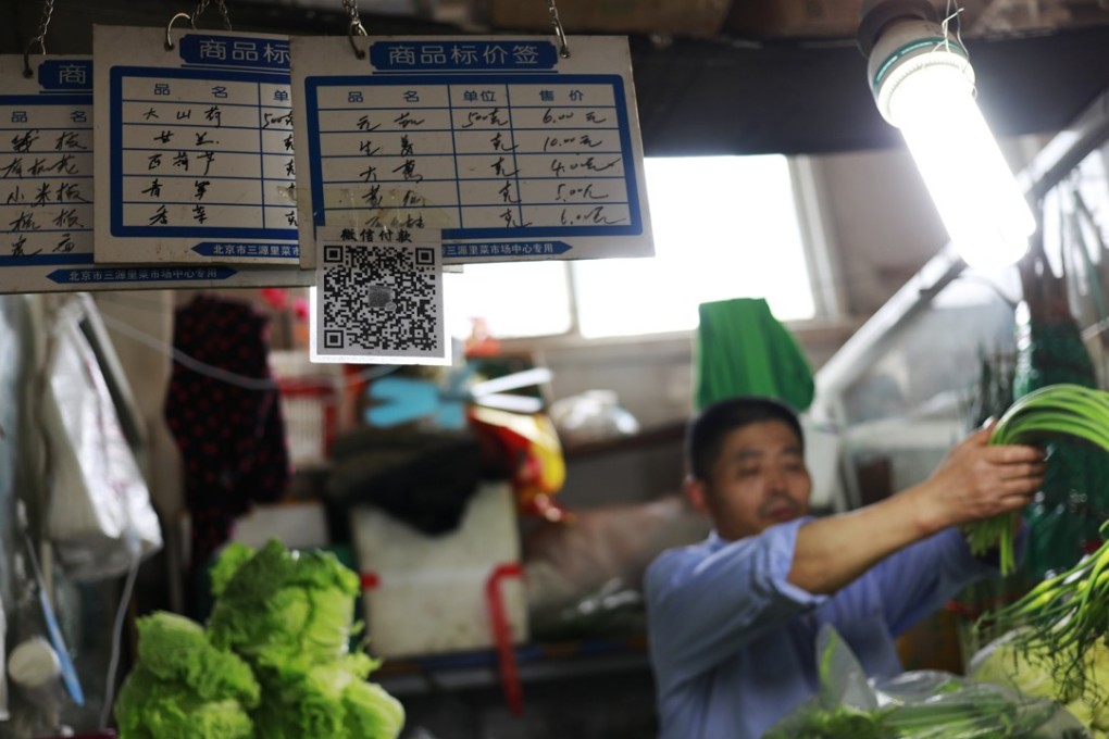 Prices and QR codes for mobile payment are seen hanging in a vegetable stall in a market in Beijing, China, Photo: EPA