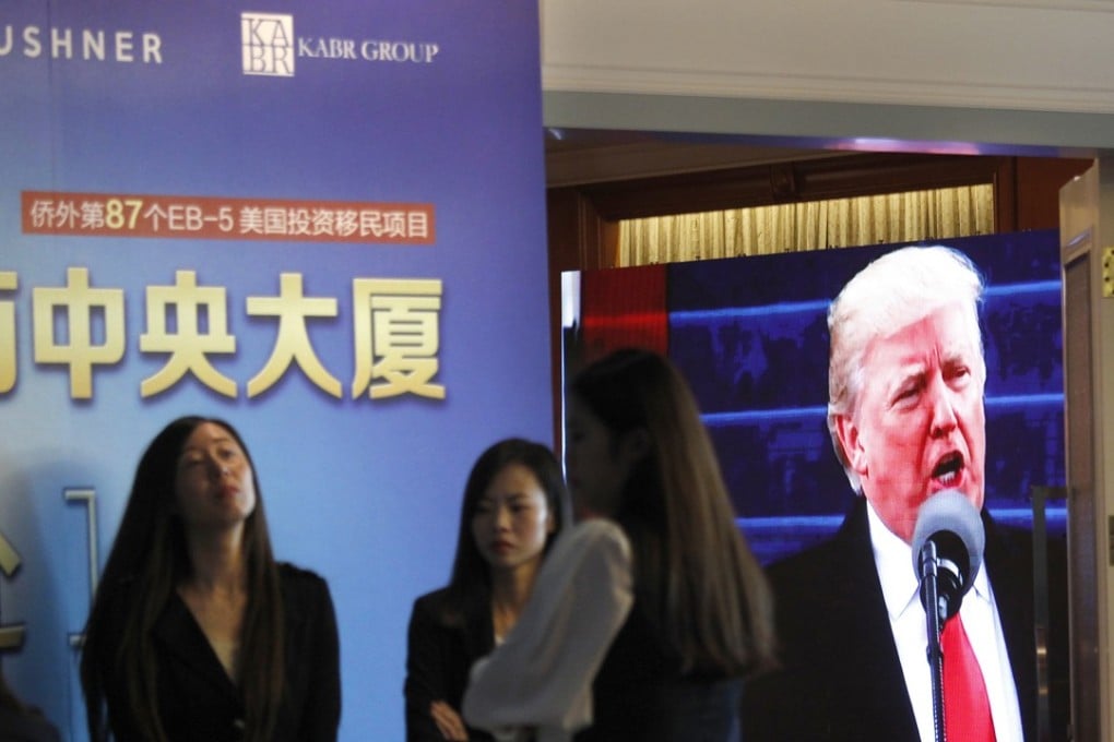In this May 7, 2017 file photo, a projector screen shows a footage of US President Donald Trump as workers wait for investors at a reception desk during an event promoting EB-5 investment in a Kushner Companies development, at a hotel in Shanghai, China. Photo: AP