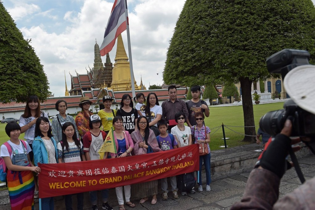 A group of Chinese tourists pose for a picture before visiting the Grand Palace in Bangkok. Photo: AFP