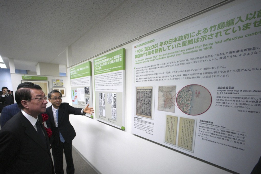 Tetsuma Esaki, left, minister in Charge of Territorial Issues, watches maps of the island known as Takeshima in Japanese and as Dokdo in Korean, claimed by both Japan and South Korea, at the National Museum of Territory and Sovereignty in Tokyo. Photo: AP