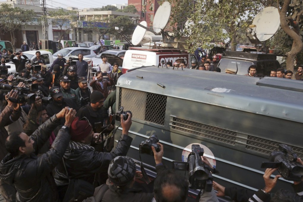 Surrounded by journalists and security forces, a prison van carrying Mohammad Imran, who is accused of the brutal killings of eight children in the eastern city of Kasur, heads to a courthouse, in Lahore, Pakistan, Wednesday. Photo: AP