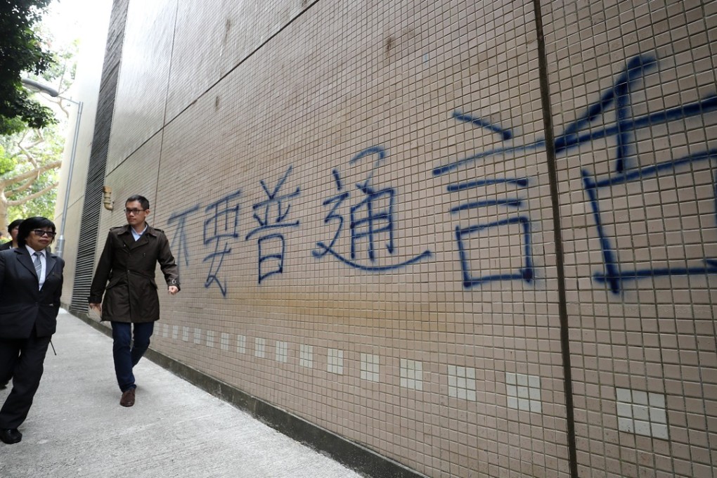 Police follows up on the "No Putonghua" graffiti near the wall of the Baptist University Sports Centre in Kowloon Tong. Photo: Winson Wong