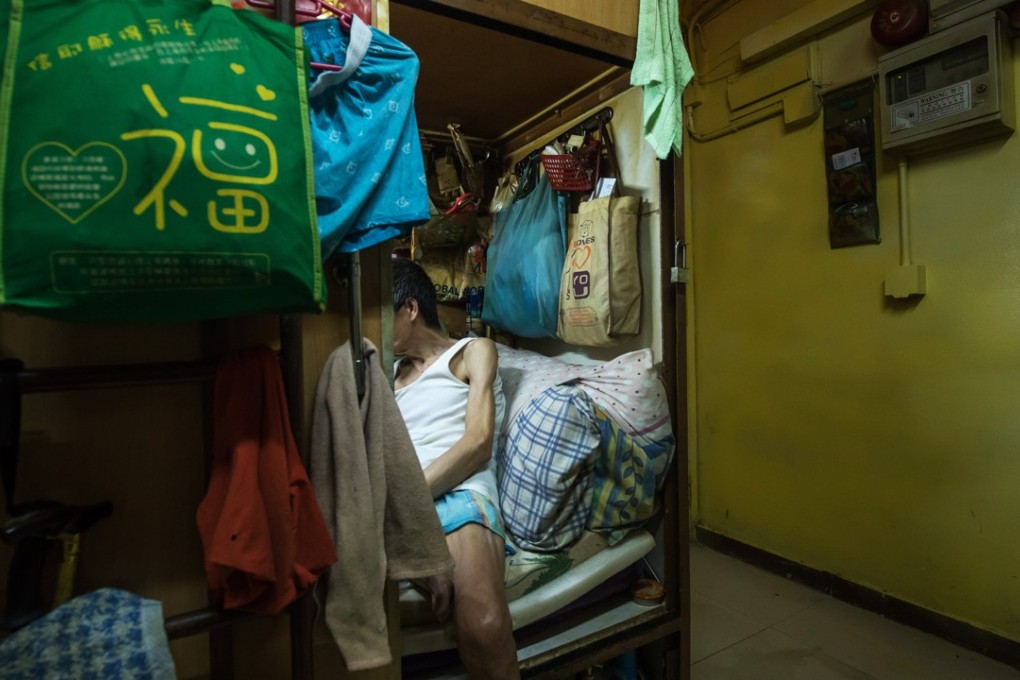 An occupant sits inside a subdivided residential unit, located inside a building in Hong Kong. Photo: Bloomberg