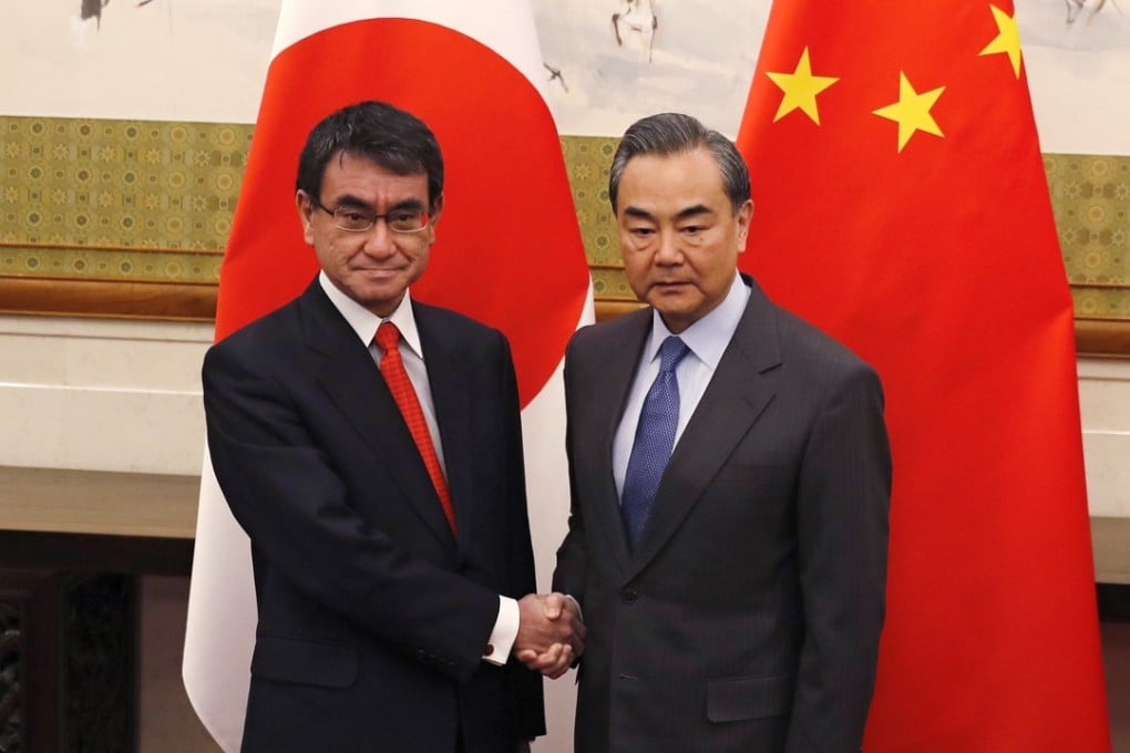 Japanese Foreign Minister Taro Kono (left) and Chinese counterpart Wang Yi head into talks at the Diaoyutai State Guesthouse in Beijing on Sunday. Photo: AP