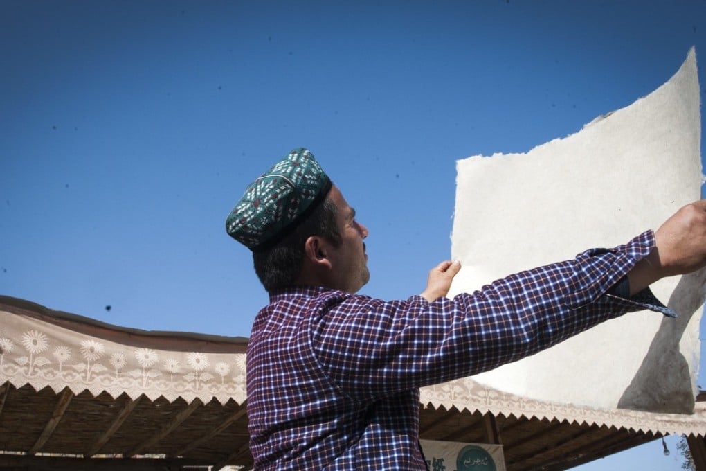 Ablimit checks a piece of sun-dried mulberry-bark paper in Moyu County of Hotan City, in the Xinjiang Uygur autonomous region on November 4, 2016. The handmade mulberry-bark paper, originating thousands of years ago in Xinjiang, has been listed as intangible cultural heritage by the Unesco. Photo: Xinhua/Wei Hai