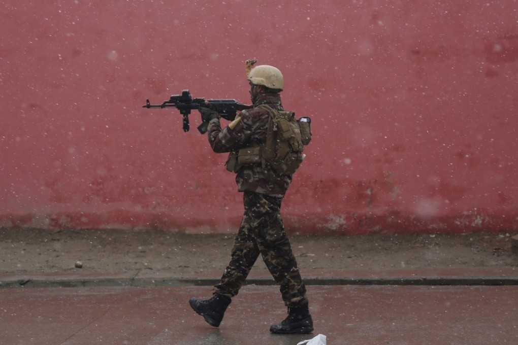 A member of Afghan security personnel arrives at the site of an attack at a military academy in Kabul on Monday. Photo: AP