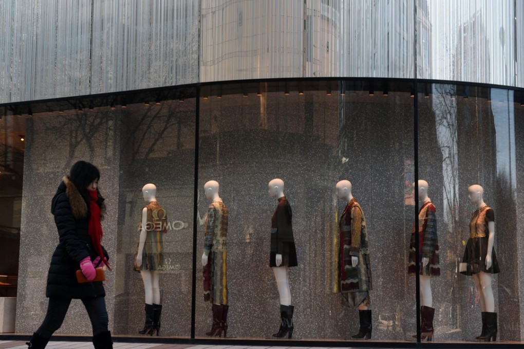 A woman walks past a fashion outlet in Beijing. Photo: AFP