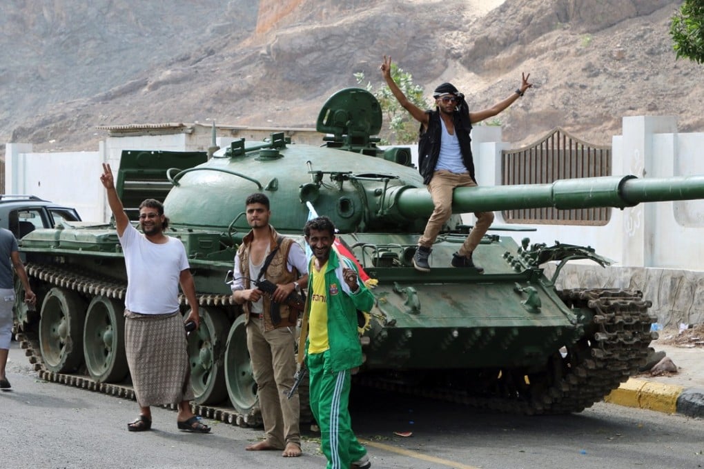 Southern Yemeni separatists stand by a tank in the port city of Aden, where the prime minister is preparing to flee. Photo: Reuters