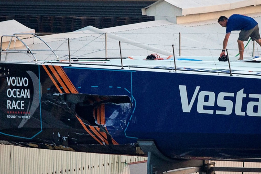 A crew member of Vestas 11th Hour Racing on their damaged yacht, as it sits in a dock for repairs after a collision with a fishing vessel. The team will skip the next two legs of the Volvo Ocean Race. Photo: AFP