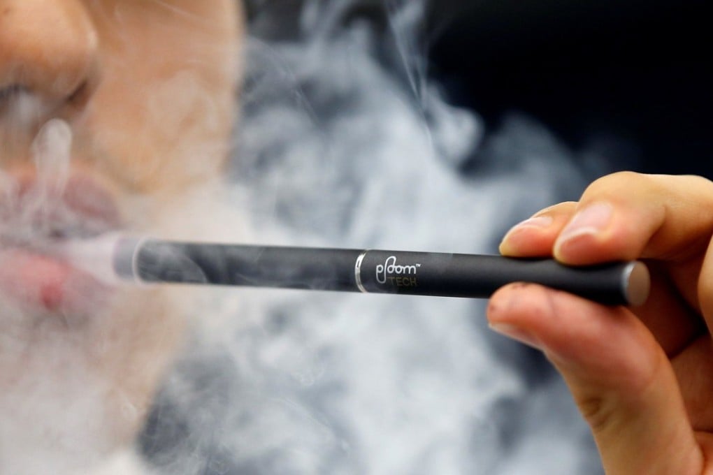 A shop assistant shows a Japan Tobacco Inc's Ploom Tech smokeless vaping product at its Ploom Shop in Tokyo, Japan, in June 2017. A new report suggests that vaping can increase the risk of cancer due to DNA damage, despite having fewer carcinogens than traditional cigarettes. Photo: Reuters