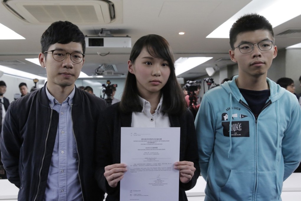 Agnes Chow Ting of Demosisto holds up a notice from the Hong Kong government barring her from contesting the March by-election to the Legislative Council, on January 27. Flanking her are fellow Demosisto members Nathan Law Kwun-chung (left), the disqualified Hong Kong Island lawmaker whose seat she had hoped to run for, and Joshua Wong Chi-fung. Photo: AP