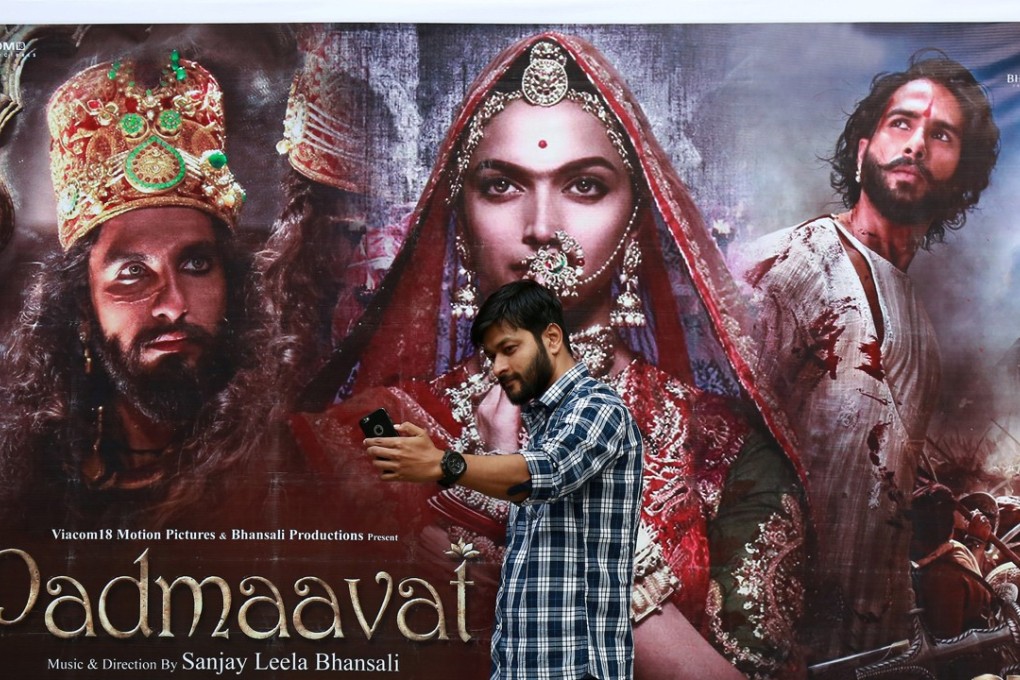 A young man takes a selfie in front of a poster of Bollywood movie Padmaavat, outside a theatre in Kochi, India. The film, which has come under fire in India, has been banned in Malaysia. Photo: Reuters