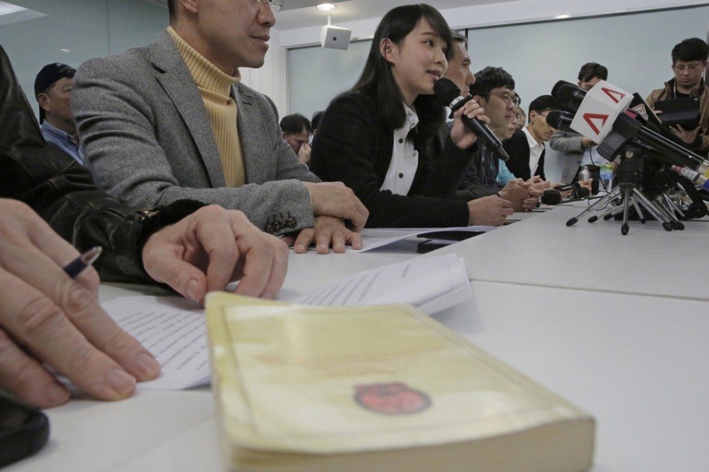 Agnes Chow speaks at a press conference on January 27, after she was banned from taking part in the March by-elections. A copy of Hong Kong’s Basic Law lies on the table. Photo: AP