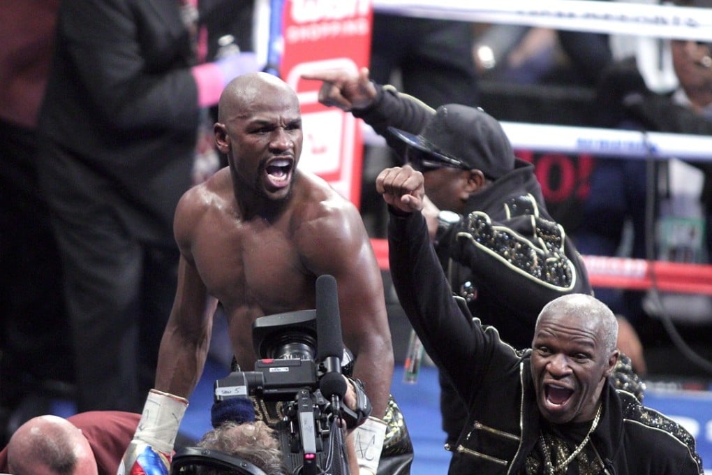 Floyd Mayweather Jnr and his father celebrate victory over mixed martial arts star Conor McGregor. Photo: AFP