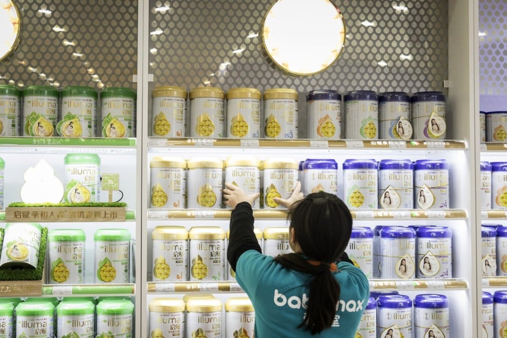 An employee arranges cans of Illuma infant formula, produced by Nestlé, on a shelf at store in Shanghai. Photo: Bloomberg