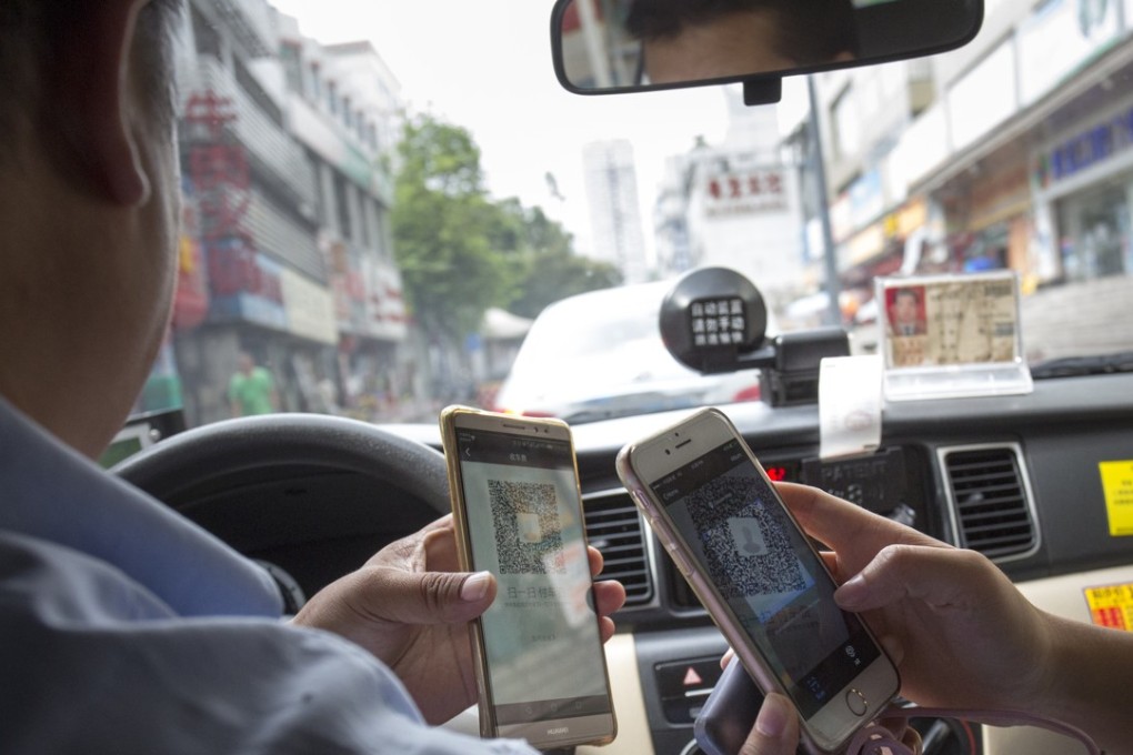 A passenger pays for her taxi ride by mobile payment in Shenzhen, southern China. Chinese consumers spend 50 times more on mobile payments than their American counterparts. Photo: May Tse