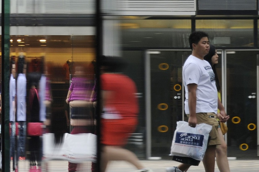 A file picture of shoppers reflected in a window at a mall in Beijing. Photo: Agence France-Presse