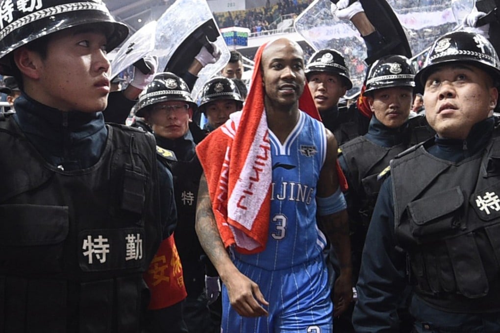 Stephon Marbury is protected by security as leaves the court after playing for the Beijing Ducks. Photo: AP