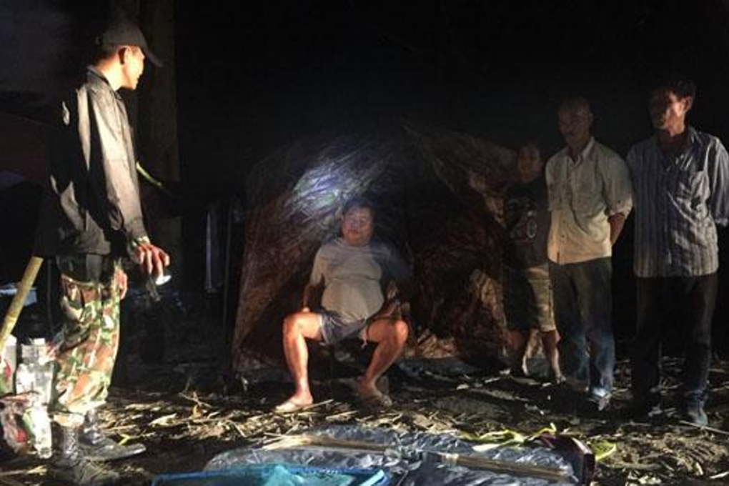 A park ranger stands guard over Italian-Thai Development Plc president Premchai Karnasuta, sitting, and the other suspects at their hunting camp in Thungyai Naresuan Wildlife Sanctuary in Kanchanaburi province. Photo: Piyarach Choncharoen/Bangkok Post