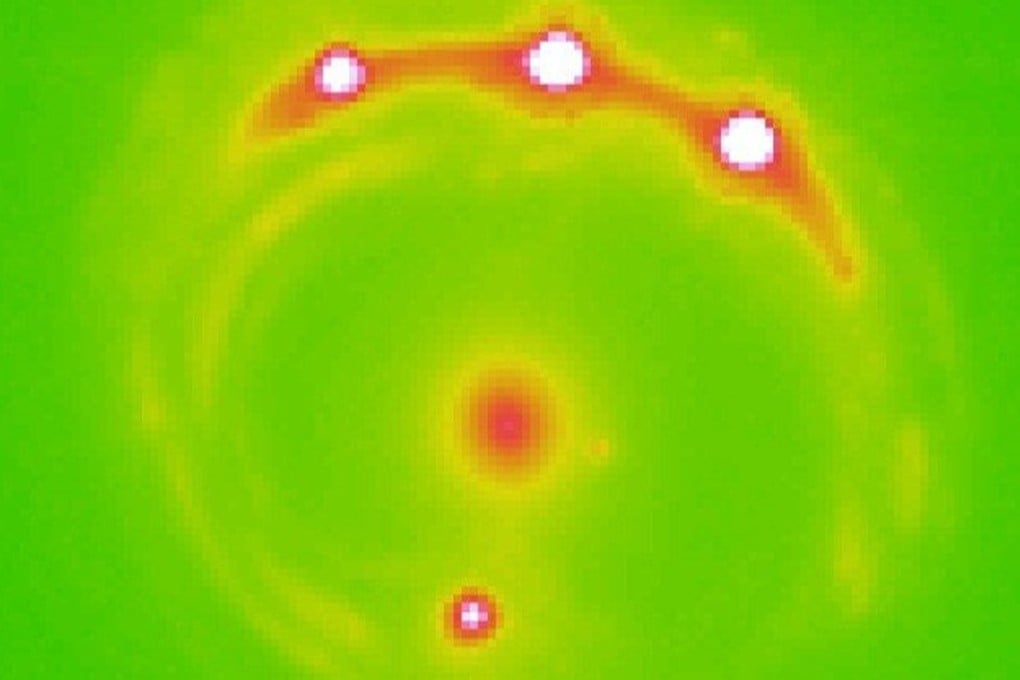 The lens galaxy, at centre, and four lensed background quasars – evidence, say researchers, of the first planets beyond our Milky Way galaxy. Photo: University of Oklahoma.