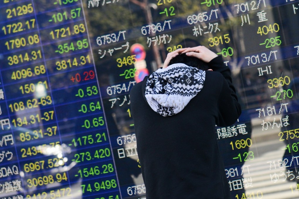A man reacts after looking at an electronic stock board outside a securities firm in Tokyo, Japan, on Tuesday, Feb. 6, 2018. Japan’s blue-chip Nikkei 225 Stock Average entered a correction as the nation’s shares posted the biggest decline since November 2016, following U.S. peers lower amid rising concern that inflation will force interest rates higher. Photo: Noriko Hayashi/Bloomberg