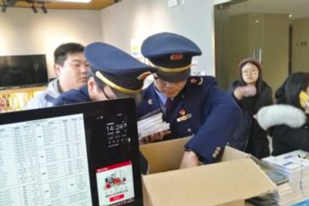 Officials seen during an inspection of the bogus Apple repair centre. Photo: Fawan.com