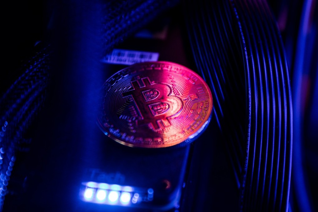 A bitcoin token sits among cables and LED lighting inside a 'mining rig' computer in this arranged photograph. Cryptocurrencies are not living up to their comparisons with gold as a store of value, tumbling Monday as an equities sell-off in Asia extended the biggest rout in global stocks in two years. File photo: Bloomberg