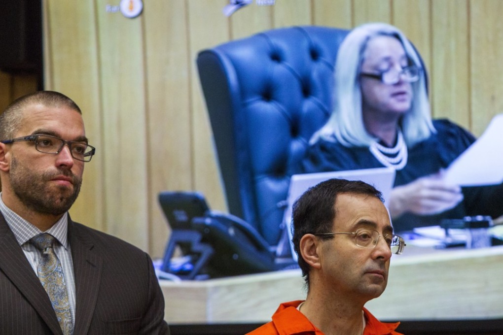 Larry Nassar (right) and his defense attorney Matthew Newberg listens as Judge Janice Cunningham (pictured on the monitor) sentences Nassar at Eaton County Circuit Court in Charlotte, Michigan on February 5, 2018. Photo: The Grand Rapids Press via AP