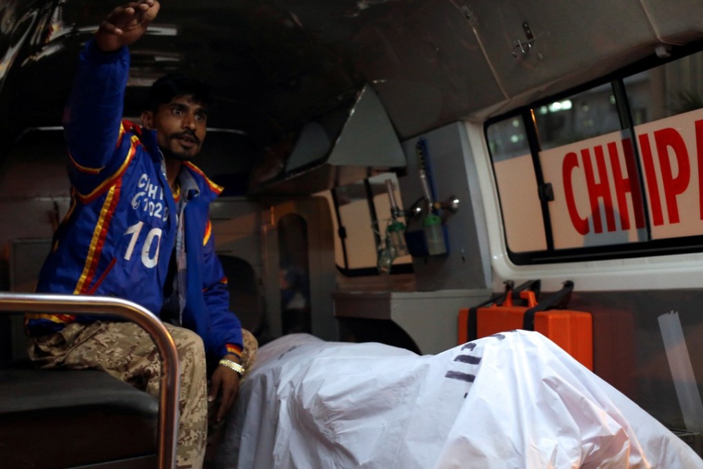 A rescue worker sits in an ambulance with the body of a Chinese man who was working with a shipping company in Pakistan, after he was shot dead in what police described as a targeted attack in Karachi, Pakistan, on February 5, 2018. Photo: Reuters