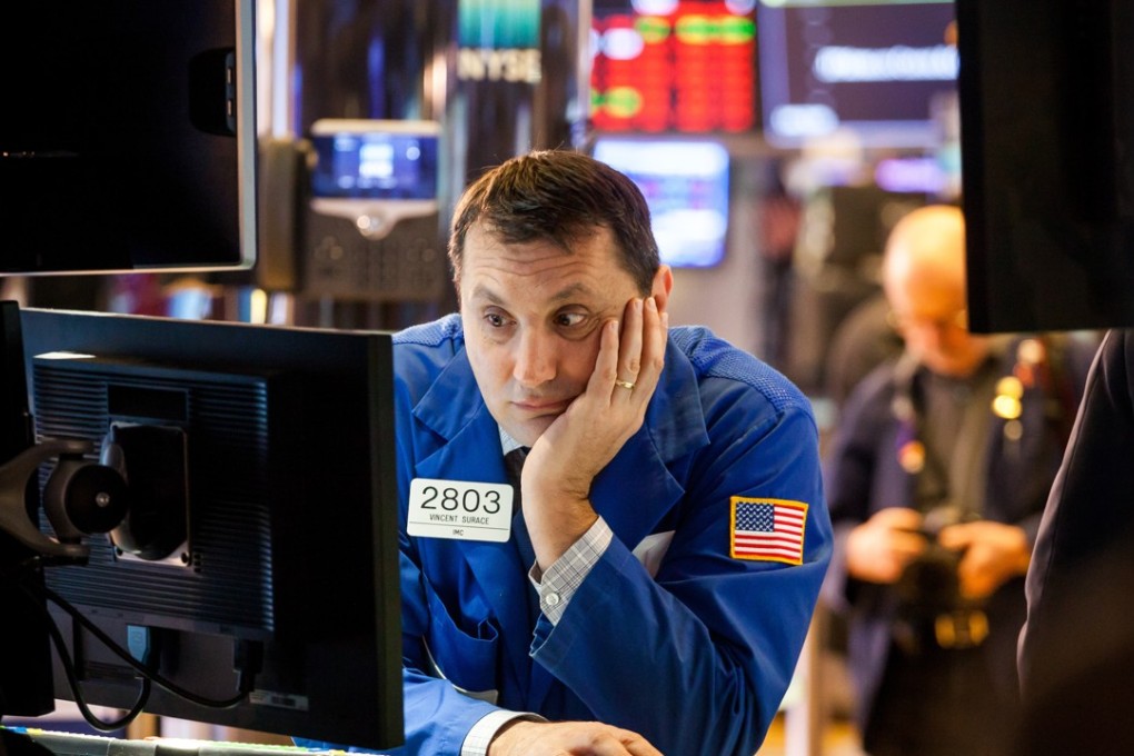 A trader glumly looks at gyrating stocks prices on the floor of the New York Stock Exchange on February 6, 2018. US equity indexes climbed higher after a rocky start, and the benchmark gauge for US share volatility reversed course after hitting a two-year high. Photo: Bloomberg