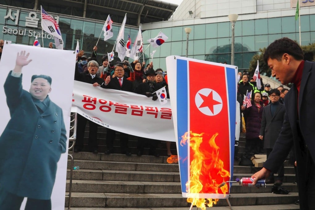 South Korean protesters burn a North Korean flag and a picture of North Korean leader Kim Jong-un during an anti-North Korea rally outside Seoul Station on January 22 as a North Korean delegation arrives. Photo: AFP/Yonhap