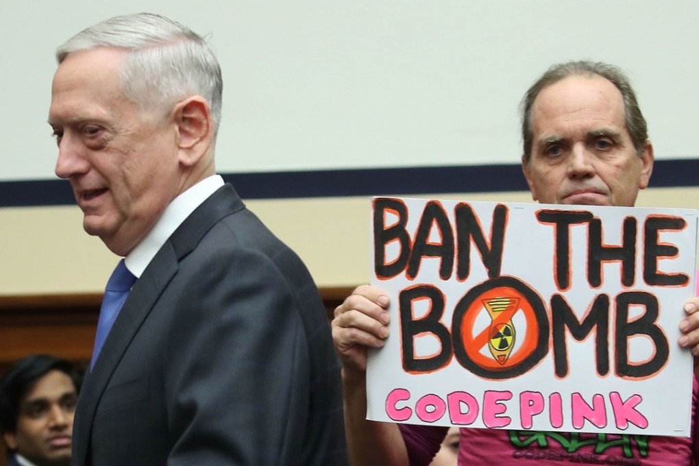 US Defence Secretary Jim Mattis walks past a protester holding a sign as he arrives at a House Armed Services Committee hearing on Capitol Hill on Tuesday. Mattis said in the hearing that the ramped-up nuclear plan proposed by the Trump administration would lead to the stability needed to denuclearise the world. Photo: Getty Images via AFP
