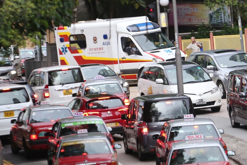 An ambulance caught in a traffic jam in Wan Chai. With crowded railways and slowing buses, more people are buying private cars, further clogging up the roads. Photo: Felix Wong