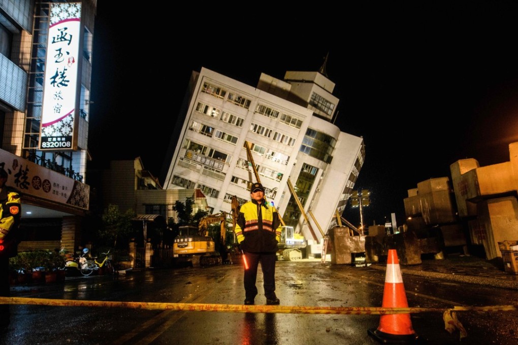 Rescuers at a cordon in front of the Yun Tsui building, which leaned to one side after an earthquake in Hualien, Taiwan. Photo: AFP