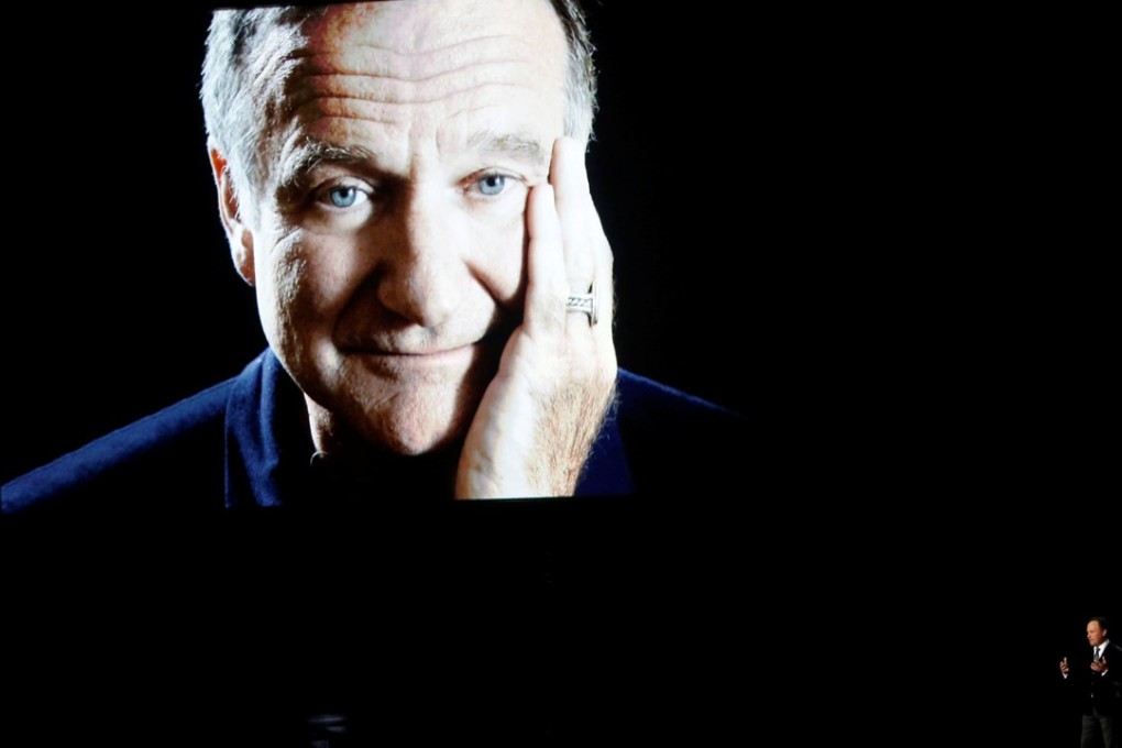 Billy Crystal (bottom right) takes the stage to pay tribute to the late Robin Williams, shown on a large screen, during the 66th Prime time Emmy Awards in Los Angeles on August 25, 2014. Photo: Reuters
