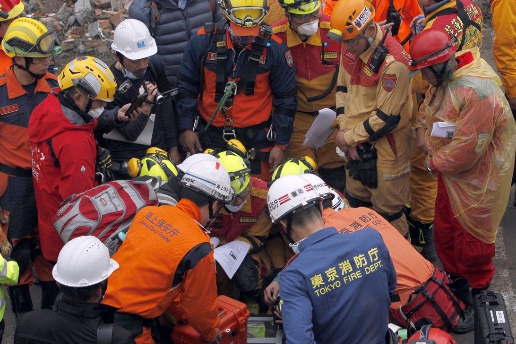 Rescuers from Japan join the search operation on Thursday at an apartment building that collapsed after a strong earthquake in Hualien. Photo: AP