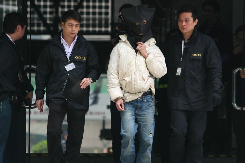 Police escort one of the suspects related to the acid attack on Neil Mitchell, outside the District Court in Wan Chai. Photo: Sam Tsang