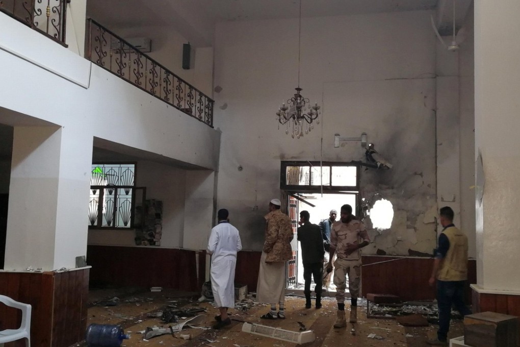 People inspect the damage inside a mosque following a twin bombing in Benghazi, Libya, on Friday. Photo: Reuters