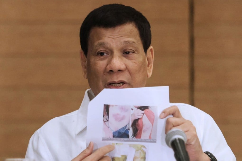 Philippine President Rodrigo Duterte shows a photo of a Filipina worker in Kuwait. Photo: AFP