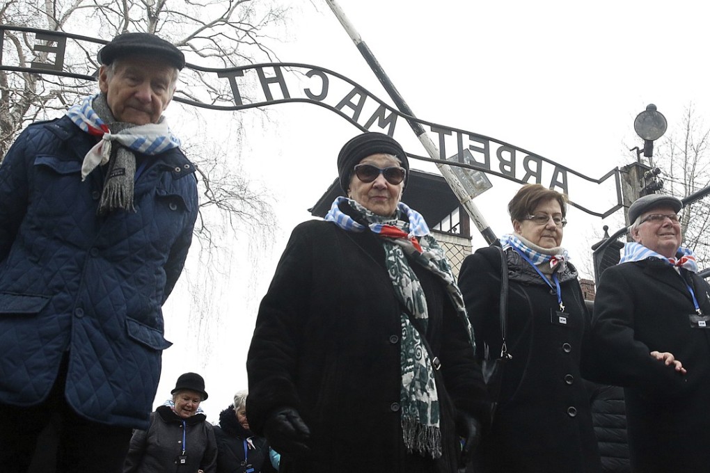 People walk past the ‘Arbeit Macht Frei’ gate at the former German concentration camp in Oswiecim, Poland. Photo: AP