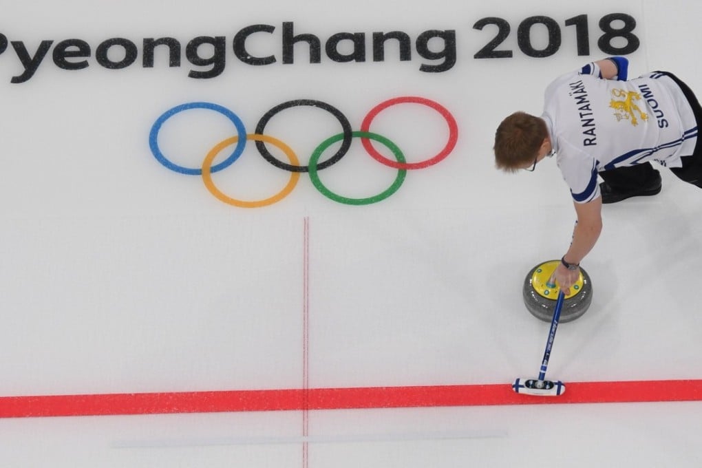 Finland's Tomi Rantamaeki sweeps the ice during the curling mixed doubles round robin session between Norway and Finland during the Pyeongchang Games. Photo: AFP