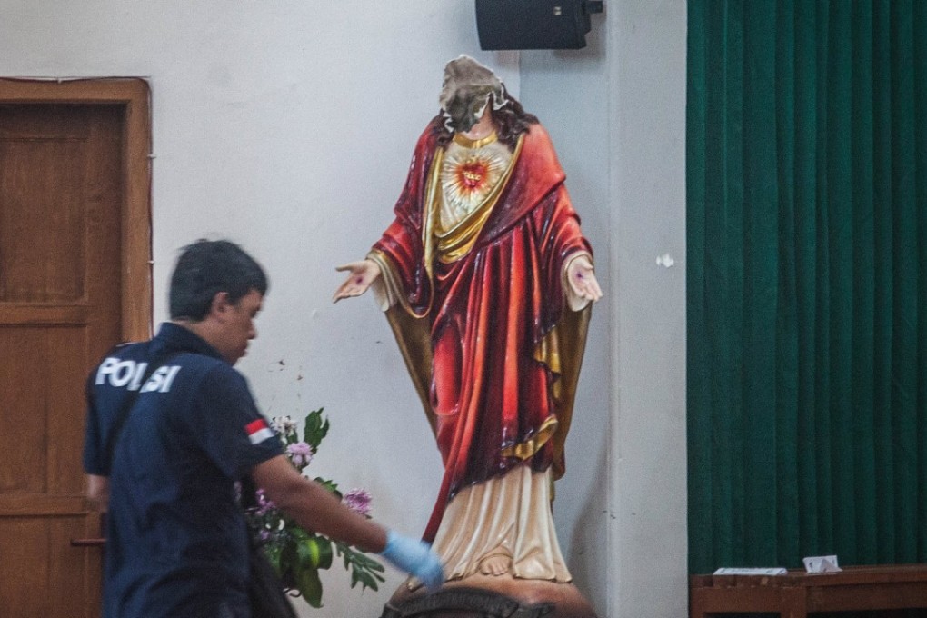 A police crime scene investigator inspects the scene of the attack at the St Lidwina Church in Sleman, Yogyakarta province. Photo: EPA
