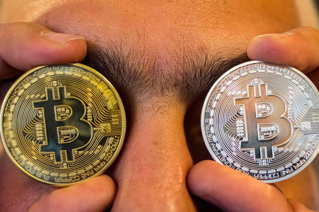 A picture taken on February 6, 2018 shows a person holding a visual representation of the digital cryptocurrency bitcoin, at the “Bitcoin Change” shop in the Israeli city of Tel Aviv. Photo: AFP