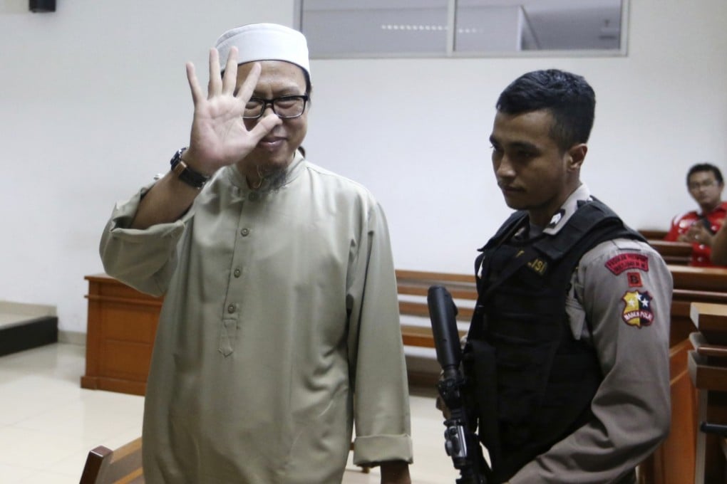 Suspected Indonesian militant Zainal Anshori waves to journalist during his sentencing hearing at East Jakarta District Court on Monday, February 12, 2018. Photo: AP