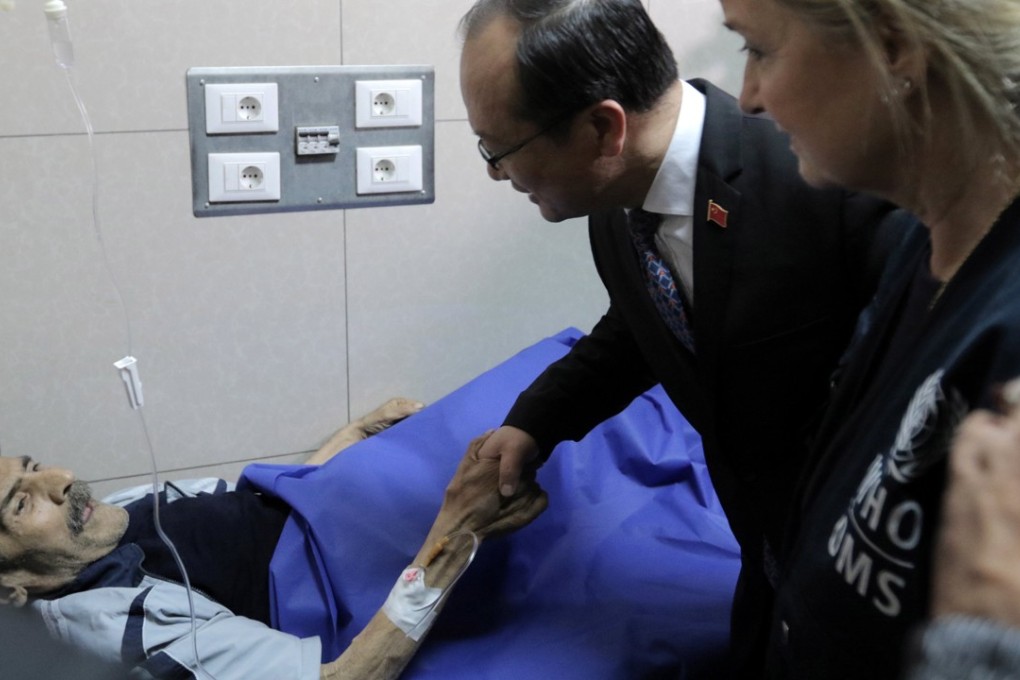 Chinese Ambassador in Damascus Qi Qianjin and World Health Organisation representative Elizabeth Hoff speak to a patient as they tour a hospital in Damascus, Syria, on Sunday. Photo: EPA