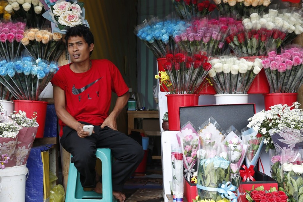 An Indonesian florist waits for customers in Bogor. Several cities across the country have banned people from celebrating Valentine’s Day. Photo: EPA